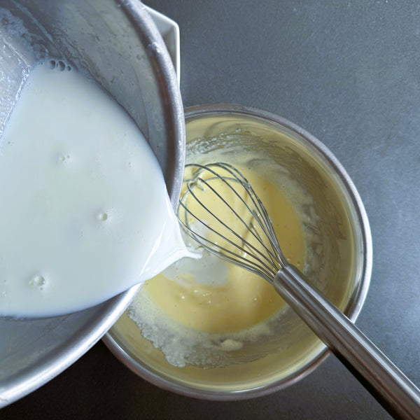 adding the milk into the egg yolk mixture