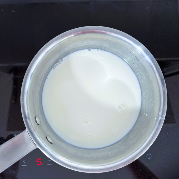 heating the milk mixture until simmering