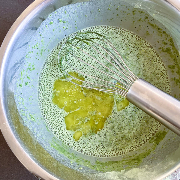 adding the melted butter to the crepe batter