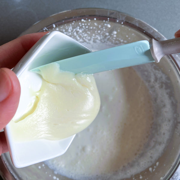 adding the condensed milk into the whipped cream