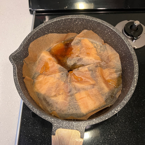 adding a piece of parchment paper over the buta no kakuni to prevent the liquid from evaporating too much