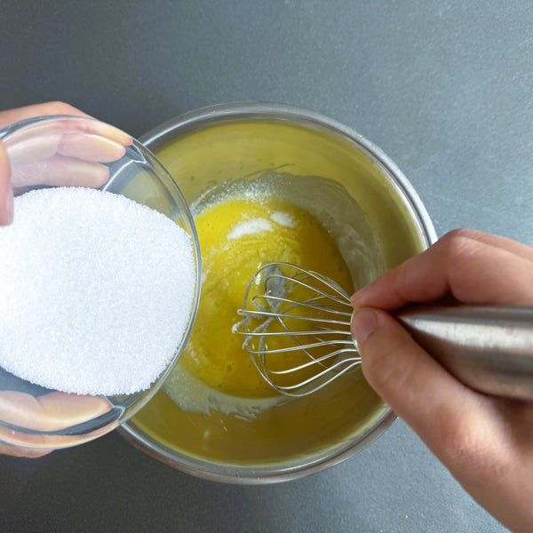 adding sugar to the eggs