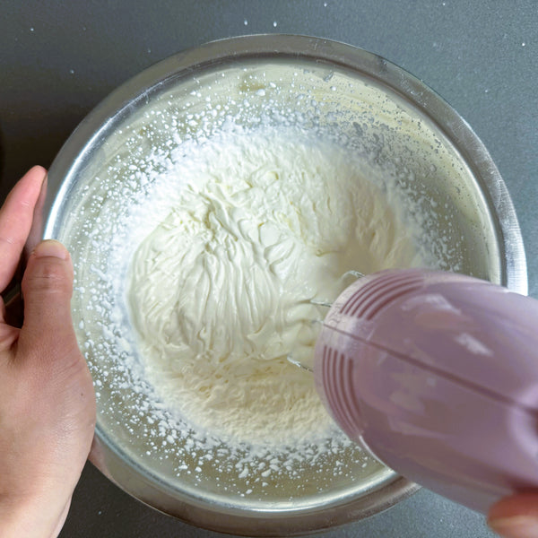 whipping the cream until it reaches soft peaks