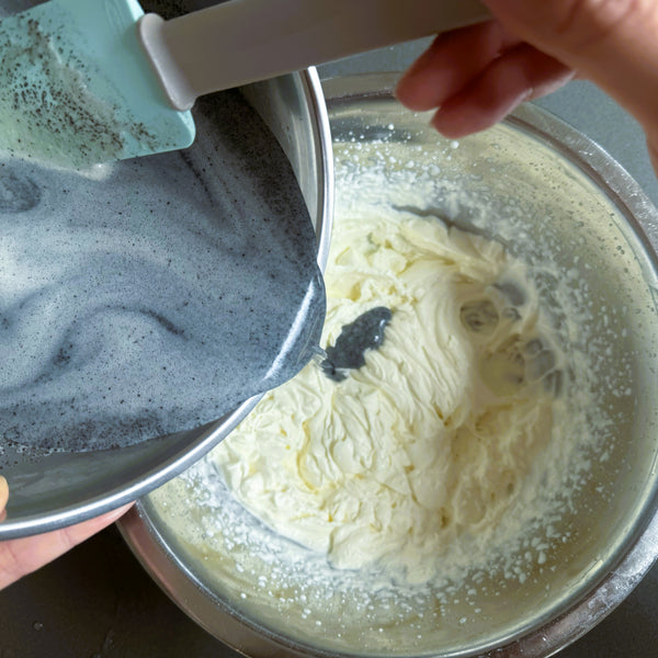 adding the black sesame mixture to the whipped cream