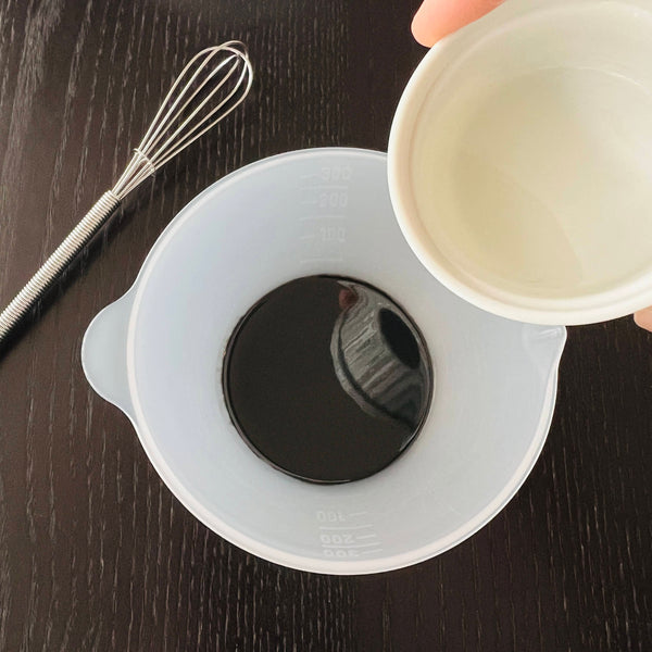 adding liquid sugar to the black sesame paste