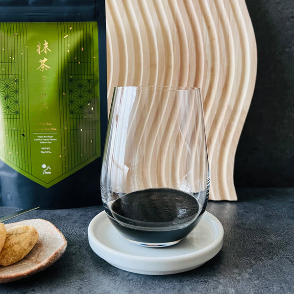 adding the black sesame paste to a glass