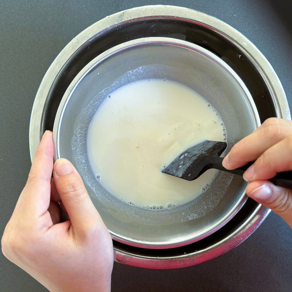 mixing the milk pudding mixture over a bowl of ice to cool it down
