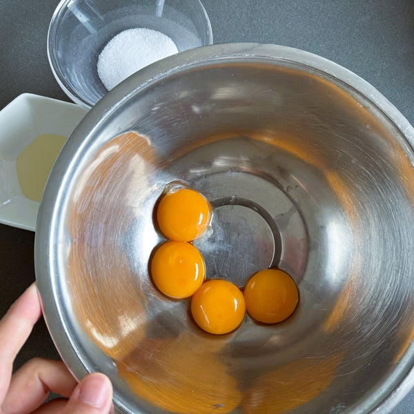 adding the egg yolks to a separate bowl