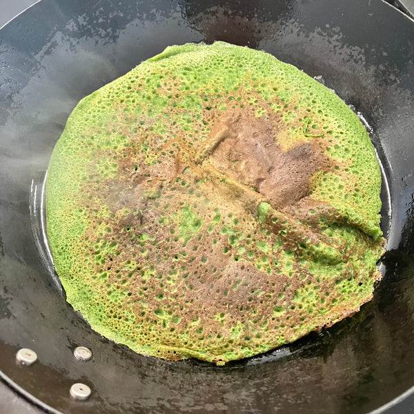 flipping the crepe and cooking it on the other side