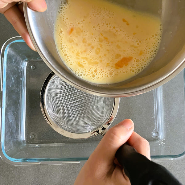 straining the custard into a fine sieve