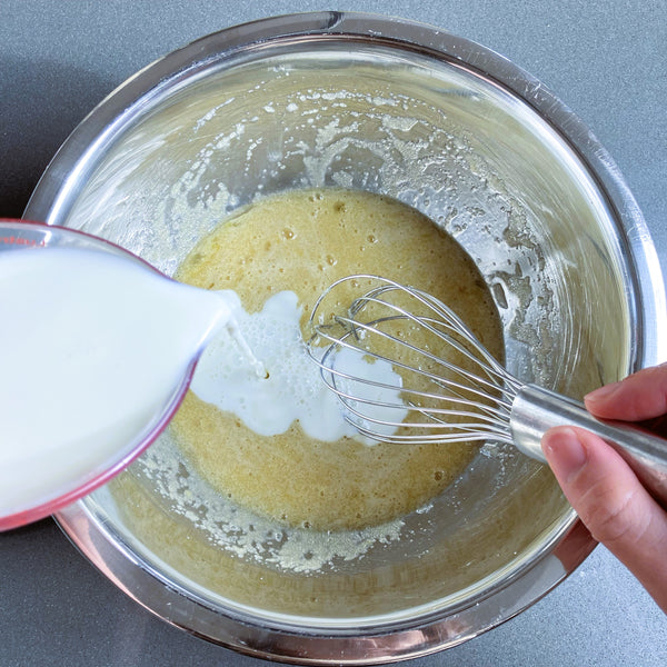 adding milk into the wet batter
