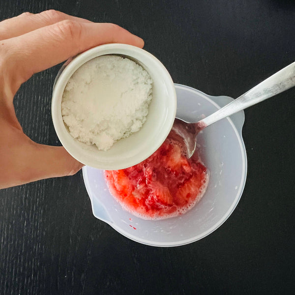 crushing the strawberries and mixing with sugar