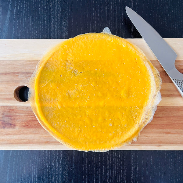 laying the egg sheet on a cutting board