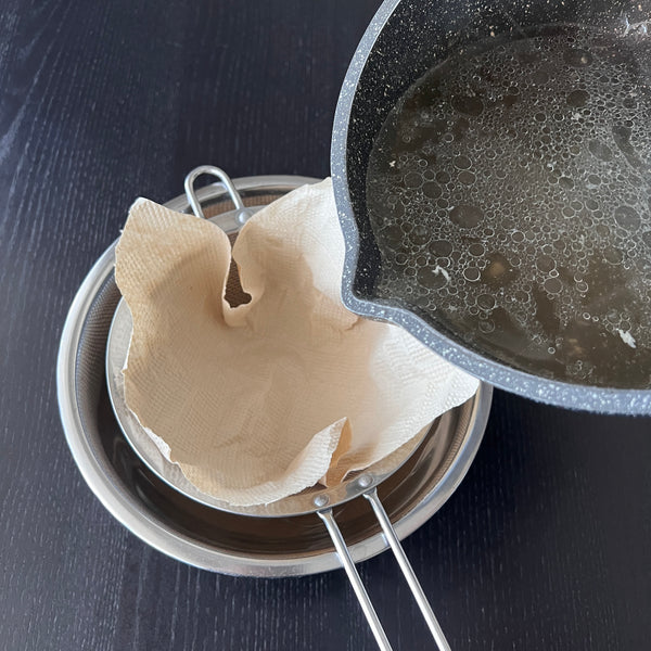 straining the broth into a bowl