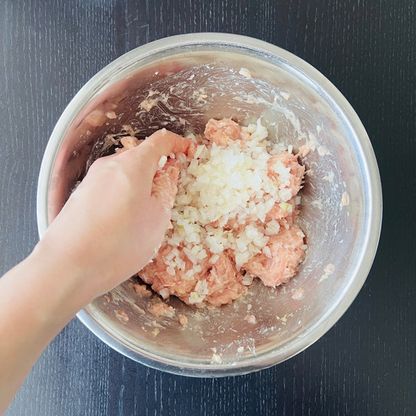 adding chopped onions to the tsukune mixture
