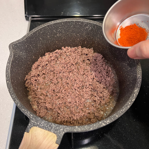 seasoning the ground beef with taco spices