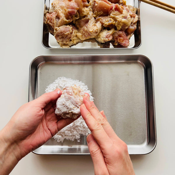 coating the other side of the chicken with potato starch